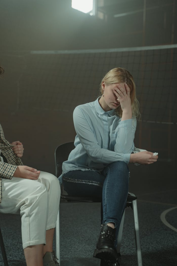 services-img-02 A woman sitting in a support group setting, visibly distressed, highlighting emotional struggles and mental health awareness.